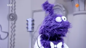 Een foto van een paarse pop in een zwart-wit getekende kamer. De pop kijkt opzij.