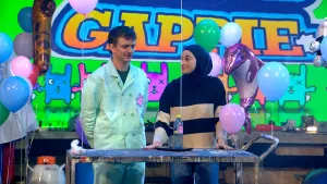 Een foto van presentator Jurre enchemicus Noor Abdulhussain in de studio. Om hen heen zijn allemaal ballonnen te zien die opgepompt zijn met helium.