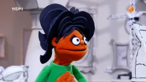 Een foto van een oranje pop in een zwart-witte kamer. Alle dingen in de kamer hebben zwarte lijntjes, alsof ze getekend zijn.