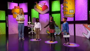 Een foto van presentator Daan die samen met drie kandidaten in de studio staat van het 'Raad eens wat ik doe' spel.