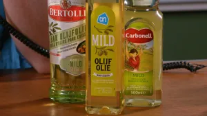Een foto van drie flessen olijfolie van verschillende merken.