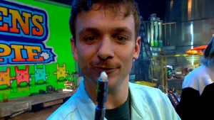 Een foto van presentator Jurre die een boormachine omhoog houdt met in plaats van een bitje een menselijke tand in de opening.