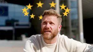 Een foto van presentator Emil die de sterren van de Europese Unie vlag in een cirkel boven zijn hoofd heeft.