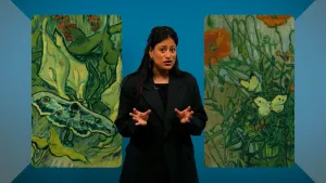 Een foto van een presentator met aan beide kanten een gedeelte van een schilderij van Vincent van Gogh. Op beide schilderijen zijn bloemen, struiken en vlinders zichtbaar.