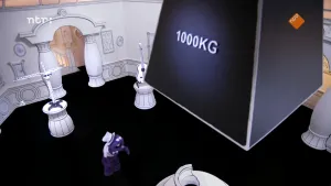 Een foto van boven genomen van een 1000 kilogram gewicht die aan het plafond hangt. Er staat een pot op een voetstuk onder met ernaast een paarse pop.