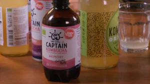 Een foto van een tafel met daarop verschillende flessen met frisdrank. Er staat een glas naast met een beetje frisdrank erin.