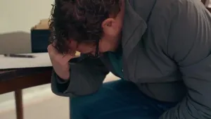 Een foto van presentator Diederik Jekel die voorover gebogen zit met een hand tegen zijn voorhoofd aan.