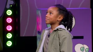 Een foto van een kandidaat die in de studio staat van het 'Raad eens wat ik doe' spel.