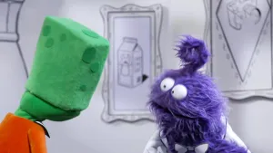 Een foto van een groene pop die naar een paarse pop kijkt in het museum van gewone dingen.