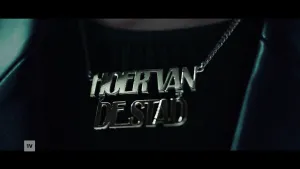 Een foto van dichtbij genomen van een hals met een zilverkleurige halsketting met de tekst 'Hoer van de stad'.