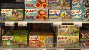 Een foto van verschillende pakken koekjes met kleurige verpakkingen in de supermarkt.