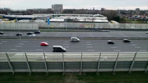 Een foto van een snelweg van de zijkant genomen. Er rijden verschillende auto's op aan beide kanten.