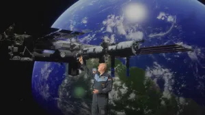Een foto van astronaut André Kuipers die naar het ruimtestation ISS wijst op de achtergrond. Achter het ISS is de Aarde zichtbaar.