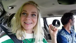 Een foto van presentatoren Janouk en Bram die in een auto zitten. Bram zit rechts achter het stuur. Janouk kijkt naar links uit het raam, Bram kijkt naar rechts uit het raam,