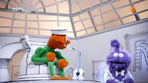 Een foto van een oranje pop die in een kapotte pot zit in het museum van gewone dingen en naar een paarse pop kijkt. De paarse pop kijkt naar de camera.