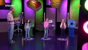 Een foto van presentator Daan die samen met drie kandidaten in de studio staat van het Raad Eens Wat Ik Doe spel.