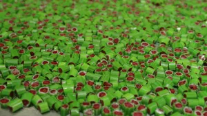 Een foto van een oppervlak geheel gevuld met groen en rood gekleurde snoepjes.