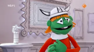 Een foto van een pop met een vikinghelm op zijn hoofd. Naast de pop is een kleine ronde tafel met daarop een brandblusser gemaakt van onder andere een plastic fles zichtbaar.