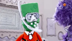 Foto van een groene pop met een duikbril op.