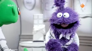 Foto van paarse pop met mond open om te praten en groene pop die naar hem kijkt.