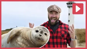 Een foto van een enthousiaste boswachter Tim met een foto van een zeehond.