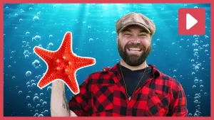 Een foto van een lachende boswachter Tim met een getekende rode zeester in de hand.