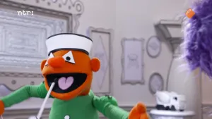 Een foto van oranje pop met groene kleding die roept.