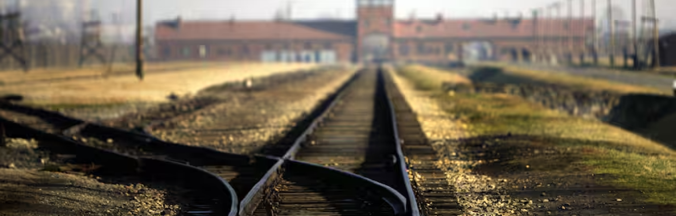 Spoorlijn en daarachter de toegangspoort van Auschwitz Birkenau