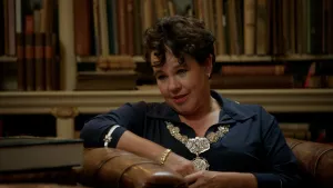 Foto van Sharon Dijksma met ambtsketen in een bibliotheek.