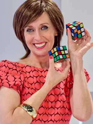 Foto van presentatrice Dorine Goudsmit met twee rubiks kubussen in het decor van Welkom in de geschiedenis