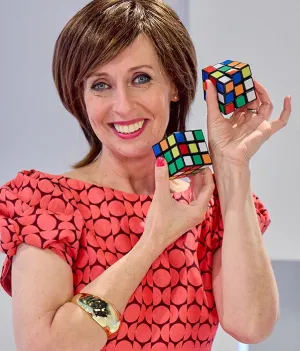 Foto van presentatrice Dorine Goudsmit met twee rubiks kubussen in het decor van Welkom in de geschiedenis