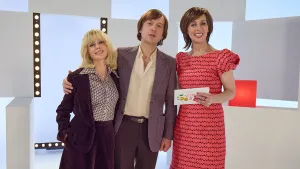 Foto van poserende presentator Dorine en acteurs die eruit zien als Johan Cruyff en zijn vrouw Danny