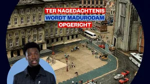 Foto van zanger Claude voor een beeld van Madurodam met daarop de tekst 'ter nagedachtenis wordt Madurodam opgericht'.