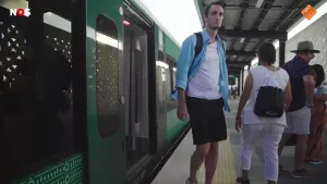 Foto van correspondent Boris van der Spek die uit een moderne trein stapt op een perron.
