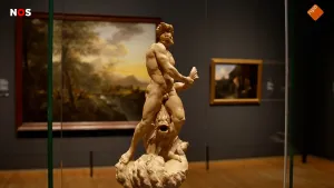 Foto van een beeld van Bernini in een hal met schilderijen. Het beeld toont een gespierde man die een vis vasthoudt.