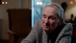 Foto van oude mevrouw die praat in haar woonkamer.