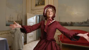 Janouk doet een ta-daa beweging in een historische rode jurk