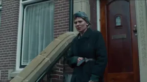 Een foto van een Joodse vrouw die met droevig gezicht uit het huis komt waar ze voor de oorlog gewoond heeft.