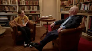 Jong meisje en oude man in gesprek in oude bibliotheek.