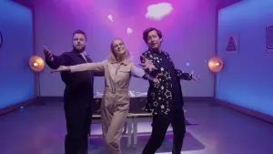 Een foto van de twee presentatoren en een ilussionist, ze spreiden hun armen "tadaaa".