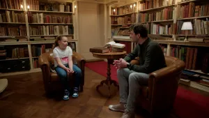 Foto van meisje in gesprek met RTL Boulevard-journalist Rob Goossens in oude bibliotheek.