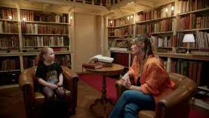 Foto van meisje in gesprek met psychologe in oude bibliotheek.