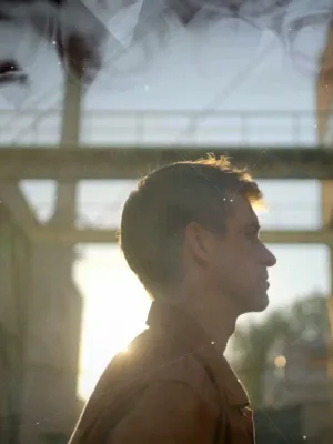 Foto van Winfried Baijens en profil in industriele omgeving.