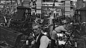 Zwart wit beeld van een fabriek met textielapparaten.