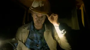 Een foto van presentator Winfried Baijens in een mijn met een bouwhelm op