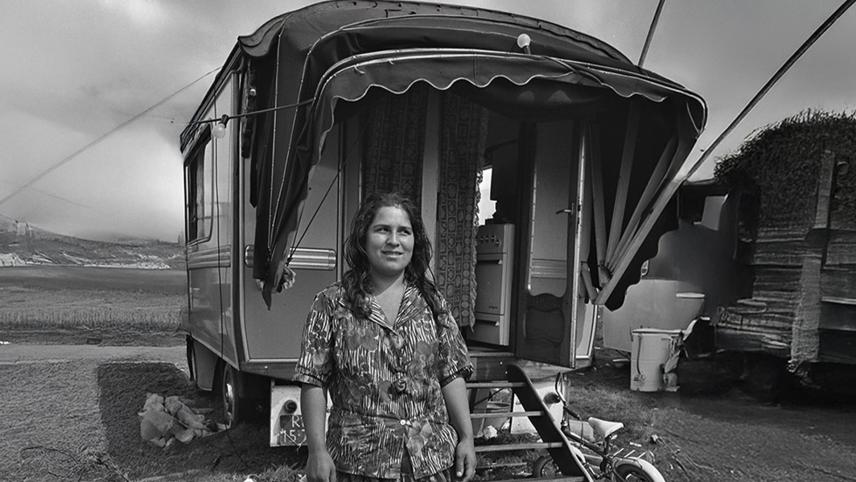 Zwartwitfoto van Romavrouw voor woonwagen.