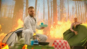 Foto van de prof en Janouk aan het kamperen terwijl er achter hen een bosbrand woedt.