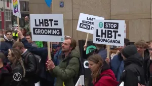Een foto van een groep mensen die protesteert, in hun handen houden ze borden met het logo van Forum voor democratie en anti LHBT-teksten.