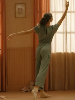 Een foto van een meisje dat in haar slaapkamer danst, je ziet haar op de rug.