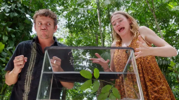 Een foto van Jurre en Emma in een bos bij een glazen bak, Jurre kijkt vastberaden, Emma heel angstig.